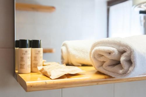 a wooden shelf with two bottles of soap and towels at Parcheggio-Camino-WiFi - Chalet immerso nella Natura in Courmayeur