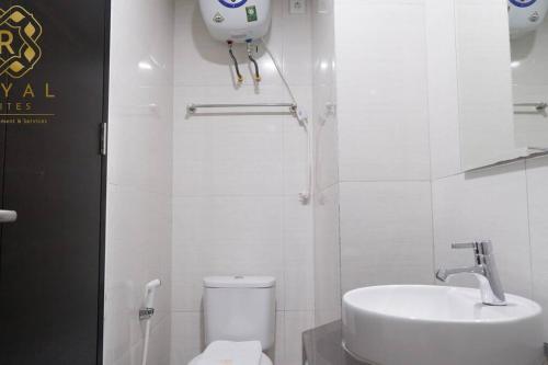 a white bathroom with a toilet and a sink at Royal Suites Studio 10ZS - Citra Plaza Nagoya in Jodoh