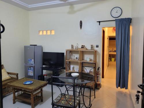 a living room with a table and a clock on the wall at Casita in Abomey-Calavi