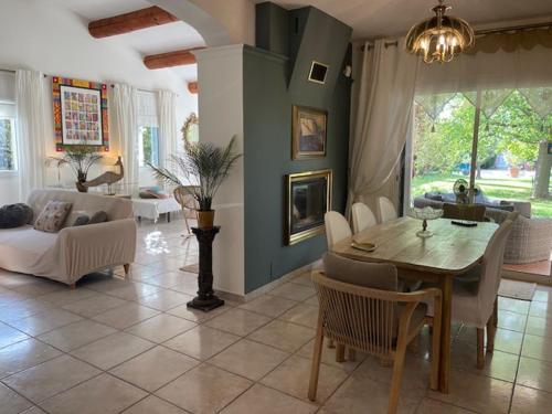 una sala de estar con una mesa y un sofá en Les Muscades, en Saint-Étienne-du-Grès