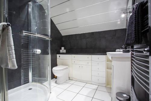 a bathroom with a shower and a toilet and a sink at Vacant Nests - The Ocean Retreat in South Shields