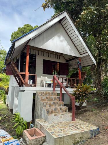 a small house with stairs leading up to it at Baan Suan Kayoo 2 Buffalo Bay Aow Khao Kwai in Ko Phayam