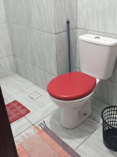 a toilet with a red seat in a bathroom at Loft Temporada Praia do Meio in Natal