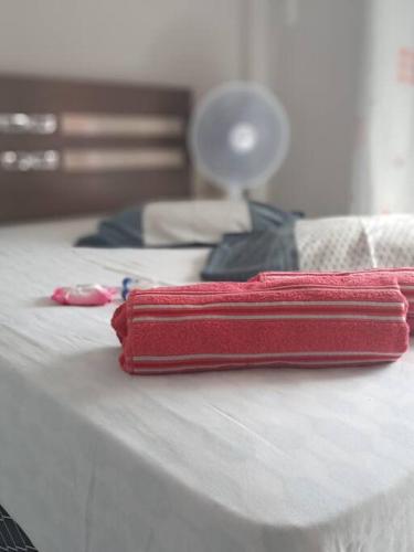 a red case sitting on top of a bed at Loft Temporada Praia do Meio in Natal