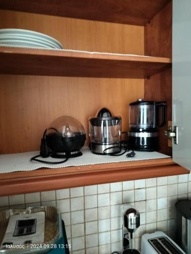 a kitchen with two pots and pans on a shelf at Periklis House in Ixia