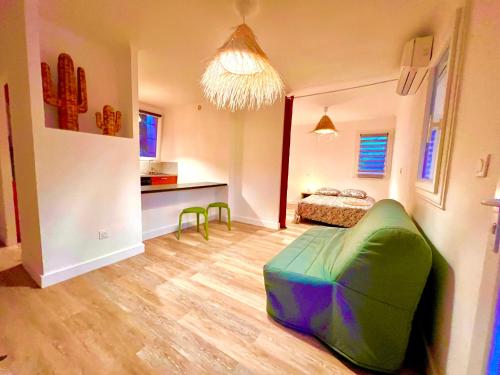 - un salon avec un lit et un pouf vert dans l'établissement Superbe logement bord de mer contigu à la Marine de Davia, à Corbara