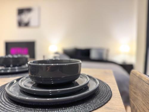 a black cup on a plate on a table at Central & Cosy Home Walking Distance To High Steet in Maidstone