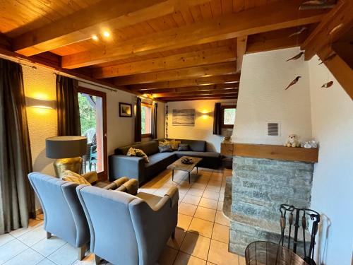 un salon avec un canapé et une cheminée dans l'établissement Vrijstaand chalet in het groen met ruim terras en 6 slaapkamers, à Oz