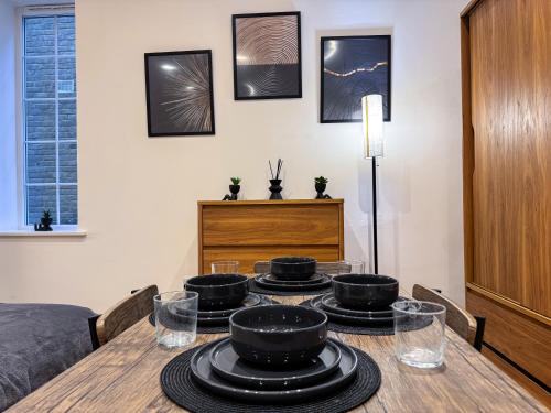 a dining room table with black bowls on top of it at Central & Cosy Home Walking Distance To High Steet in Maidstone