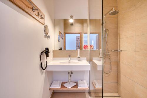 a bathroom with a sink and a shower at COOEE alpin Hotel Bad Kleinkirchheim in Bad Kleinkirchheim