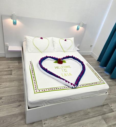 a white bed with a heart shaped cake on it at Casa De Himandhoo in Himandhoo 