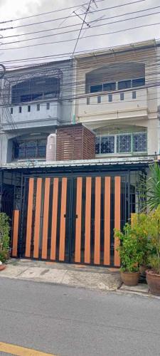 a building with a gate on the side of a street at Ben House Hatyai in Hat Yai