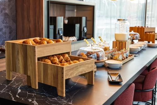 a table with two baskets of croissants and bread at TRIBE Manchester Airport by Accor in Hale