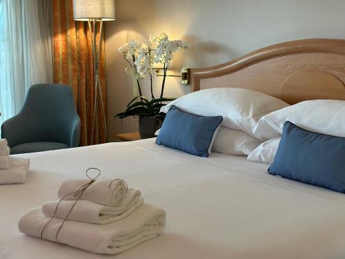 a hotel room with a bed with a towel on it at Palace Hotel Desenzano in Desenzano del Garda