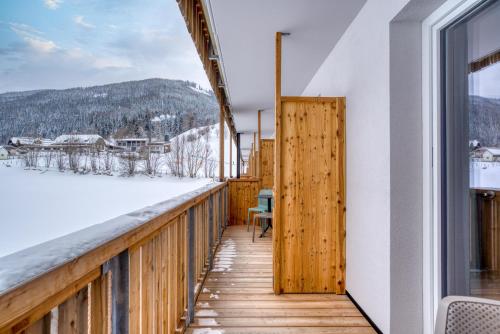 a balcony with a view of the snow covered mountains at COOEE alpin Hotel Bad Kleinkirchheim in Bad Kleinkirchheim
