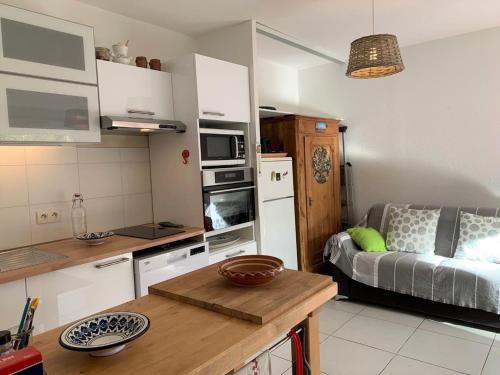 - une petite cuisine avec un canapé dans l'établissement Appartement cosy avec jardin près de la Lagune de Thau à Bouzigues, idéal pour des vacances paisibles - FR-1-604-34, à Bouzigues