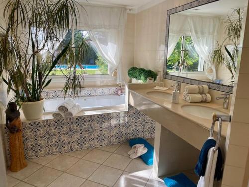 Un baño con un gran espejo y un lavabo. en Les Muscades, en Saint-Étienne-du-Grès