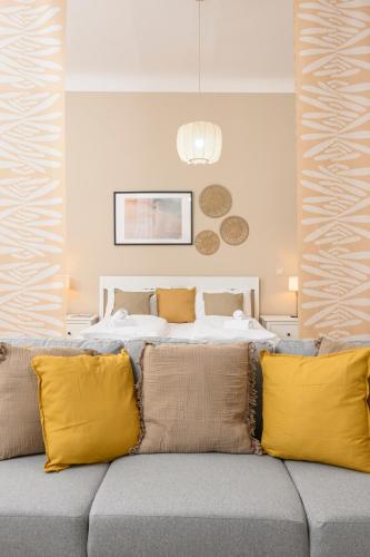 a bedroom with a bed and a couch with yellow pillows at Spacious apartment in Graz for 6 people in Graz