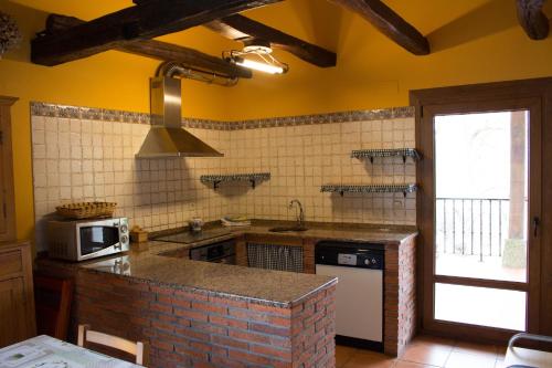 a kitchen with yellow walls and a brick counter top at Lokate 5 Habitaciones in Aia