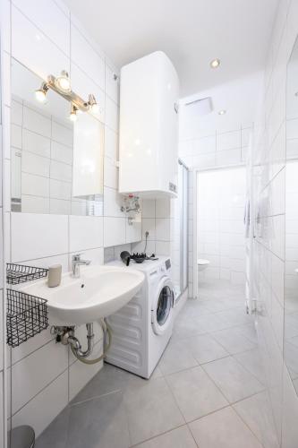 a white bathroom with a washing machine and a sink at Spacious apartment in Graz for 6 people in Graz