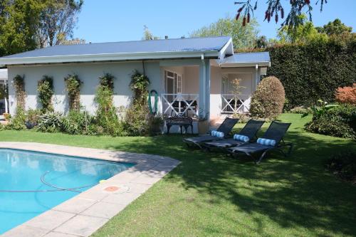 a house with a swimming pool in the yard at High Hedges Guest Suites Constantia in Cape Town