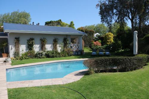 a swimming pool in the yard of a house at High Hedges Guest Suites Constantia in Cape Town