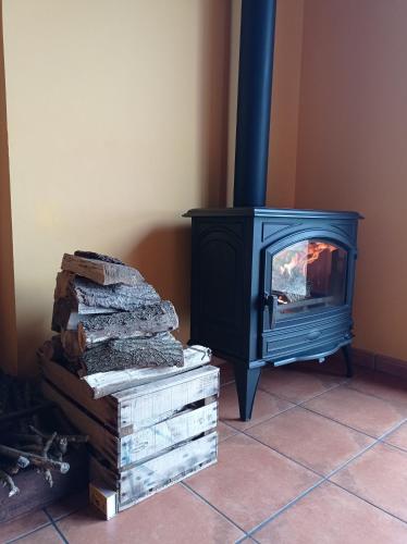 a stove with a pile of logs in a room at Lokate 5 Habitaciones in Aia