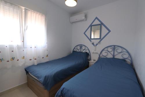 a bedroom with two twin beds and a window at Torrevieja Spectacular Townhouse in Torrevieja