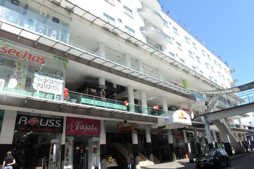 a large building with shops on a city street at Hotel San José Plaza in Bucaramanga