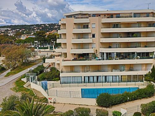un immeuble avec piscine à côté d'une rue dans l'établissement Spacieux 44m² climatisé avec terrasse, 2 pièces, cabine, Wifi, proche plage - FR-1-472A-266, à Sète