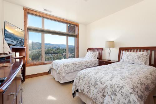 a bedroom with two beds and a large window at Peregrine Point 204 in Durango Mountain Resort