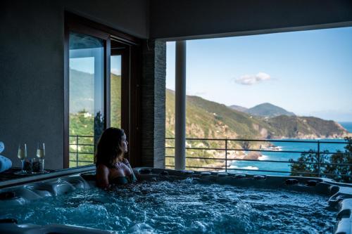 a woman sitting in a bath tub with a view at Sesta Terra Natural Resort in Framura