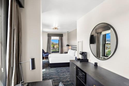 a hotel room with a bed and a mirror at Tygart Hotel, an Ascend Collection Hotel in Elkins