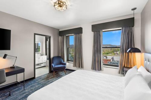 a hotel room with a bed and a desk and window at Tygart Hotel, an Ascend Collection Hotel in Elkins