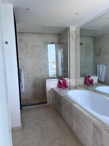 Un baño con bañera grande y ducha. en Waterside, en Lance aux Épines