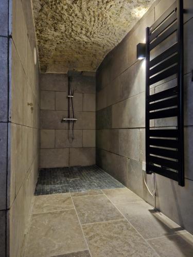 bagno con doccia e parete piastrellata di Troglodyte Loft a Saint-Étienne-de-Chigny