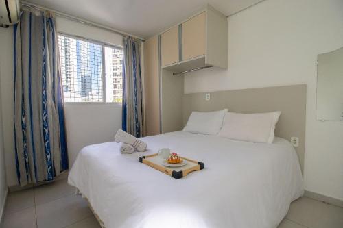 - une chambre avec un lit blanc et un plateau dans l'établissement PLT41 - Sacada Ampla com Churrasqueira, 3 Suítes, à Balneário Camboriú