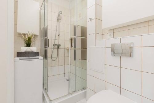 a shower with a glass door in a bathroom at HALBY rooms Walicow 20 in Warsaw