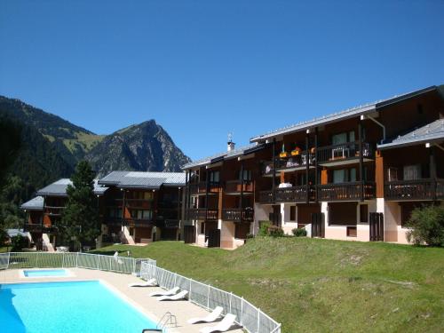 un complexe avec une piscine devant un immeuble dans l'établissement Appartement ensoleillé avec balcon, piscine chauffée, proche pistes et centre, 4 pers. - FR-1-464-220, à Pralognan-la-Vanoise