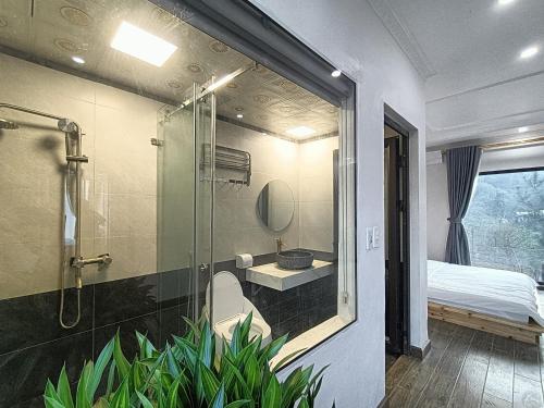 a bathroom with a shower and a toilet and a bed at Vườn Mây Homestay Sapa in Sa Pa