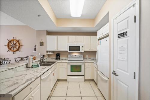 a kitchen with white appliances and white cabinets at Summerwind West 1003 in Navarre