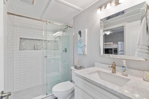 a white bathroom with a shower and a toilet and a sink at High Pointe Resort 224 in Rosemary Beach