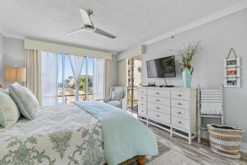 a bedroom with a bed with a television and a dresser at High Pointe Resort 224 in Rosemary Beach