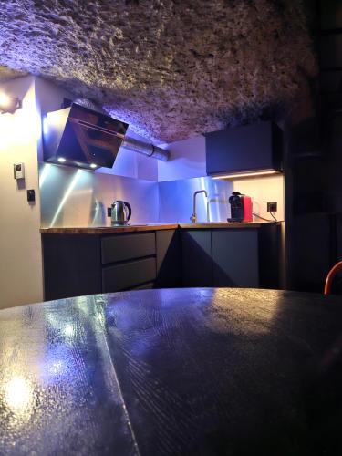 une cuisine avec une table au milieu dans l'établissement Troglodyte Loft, à Saint-Étienne-de-Chigny