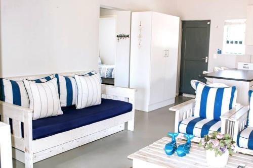 a living room with blue and white pillows and a couch at 27 On Ray in Britannia Bay