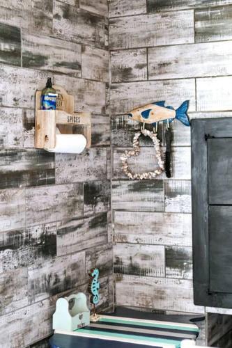a bathroom with a wooden wall with a fish on it at 27 On Ray in Britannia Bay