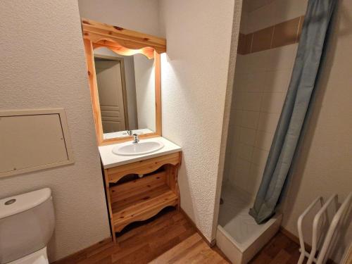 Un baño con lavabo, inodoro y espejo. en Appartement Modane 4 pièces, idéal ski, 6-8 pers, 65m², proche télécabine et commerces - FR-1-265-66, en Valfréjus