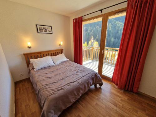 Un dormitorio con una cama y una ventana grande. en Appartement Modane 4 pièces, idéal ski, 6-8 pers, 65m², proche télécabine et commerces - FR-1-265-66, en Valfréjus