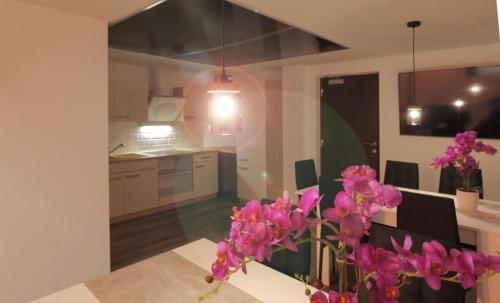 a kitchen with pink flowers in a vase on a table at Hostel Old Town in Bratislava