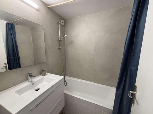 a bathroom with a sink and a tub and a mirror at Appartement 6 couchages au pied des pistes avec balcon - Auris en Oisans - FR-1-297-108 in Auris
